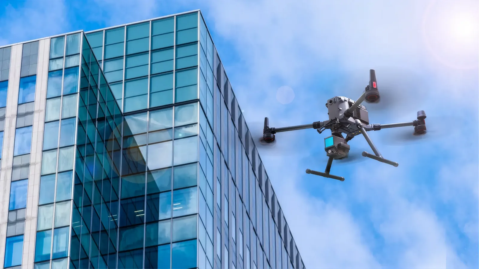 Drone flying alongside a glass-clad office tower to capture the facade