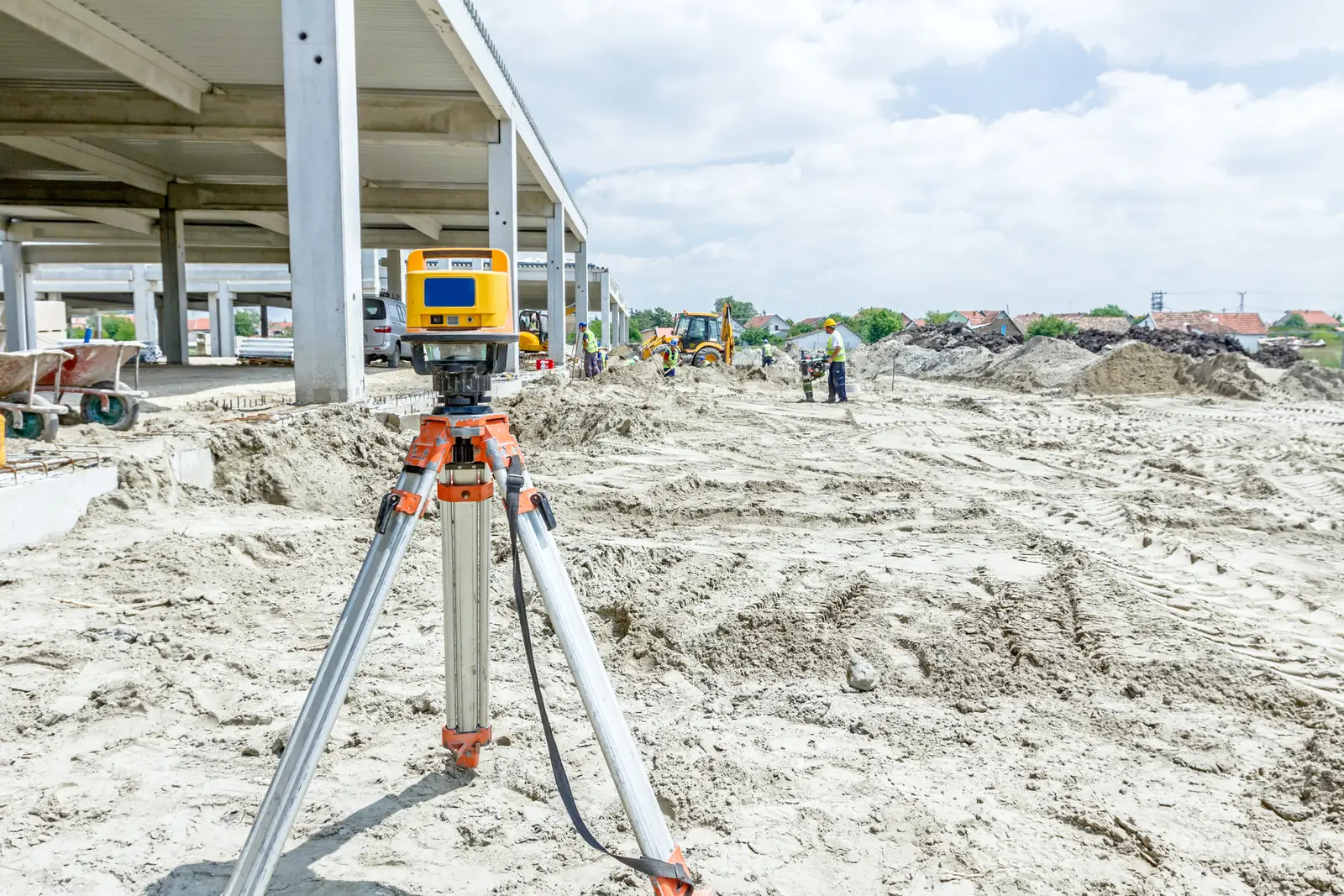Survey instrument on a tripod at a construction site before works begin